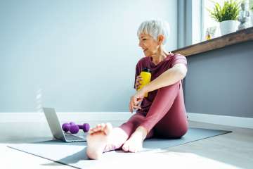 Woman working out and eating healthy food while on virtual call