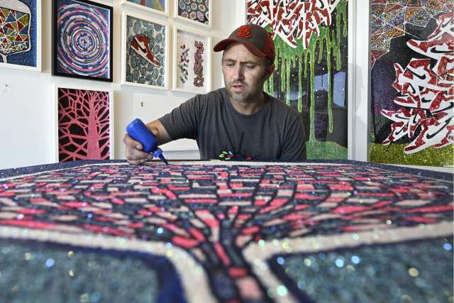 Dylan Mortimer works on a painting in his Long Beach studio.