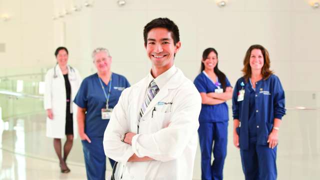 A group of doctors and hospital staff standing and smiling.