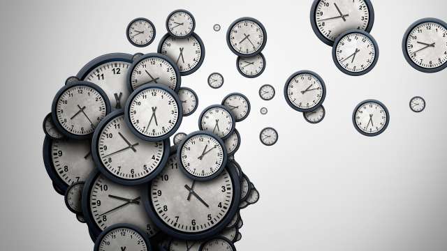 Silhouette of a human head made of many analog clocks with clocks drifting away.