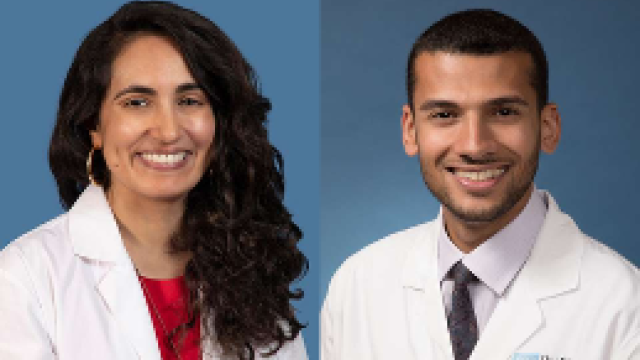 Two smiling people wearing white lab coats against blue background