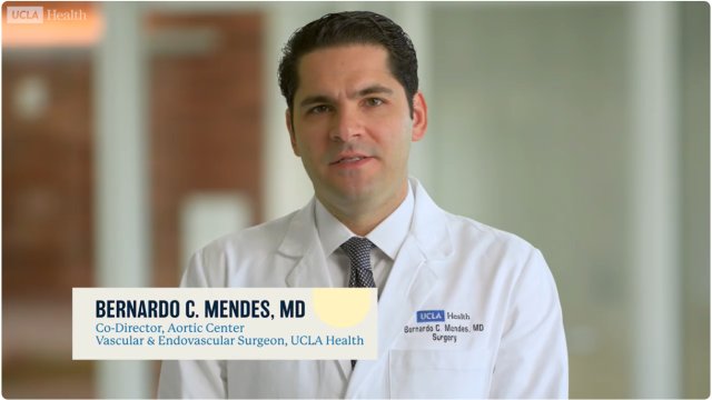 Physician in white coat with blurred face and on-screen name bar