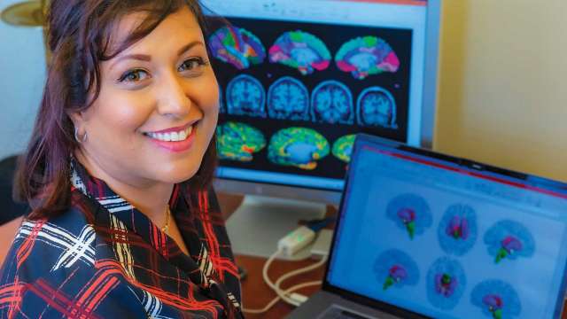 Dr. Arpana Gupta seated by monitors