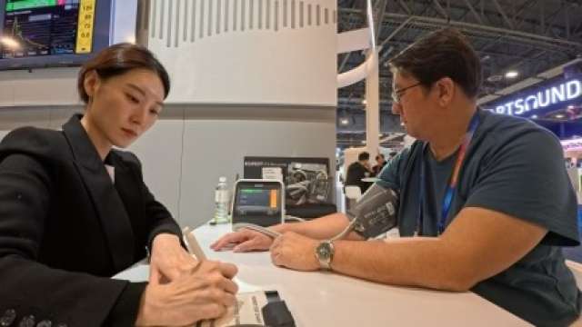 DAPM team member, Drew Cheng, shows that CES 2025 exhibits like this AI-assisted BP monitor demonstrate the narrowing gap between home health devices and clinical-grade tech