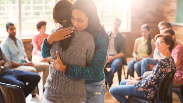 Two women hug at a cancer support group
