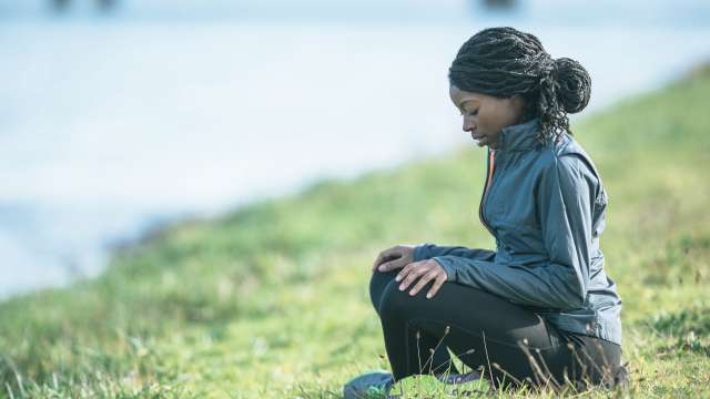 A woman meditates at a park