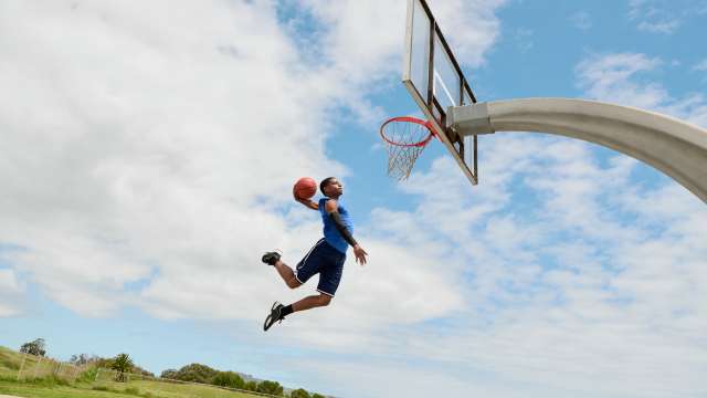 a man playing basketball on a sunny day