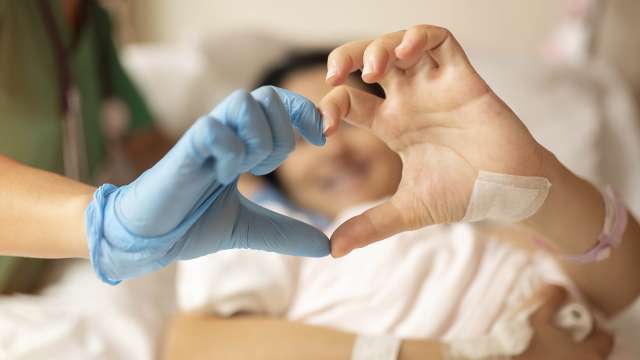 Doctor and a patient putting their hands together to form a heart