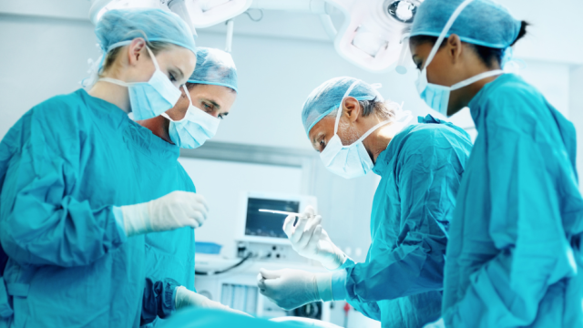 Four surgeons performing a Mesothelioma procedure in an operating room.