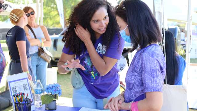 Mirella Diaz-Santos, PhD, speaks with a visitor at the Alzheimer’s Los Angeles "Making Memories Festival" at Los Angeles State Historic Park. 