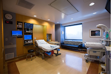 Birthing Suite - Used for vaginal deliveries. A patient's bed, monitors, medical equipment and a big window.