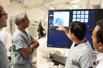 Group of doctors discussing image on monitor