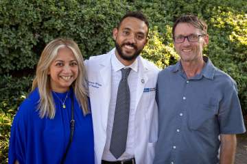 Zion Congrave-Wilson enjoys the medical school celebration with his stepmother, Michelle Borjal and father, James Wilson. (Photo by Reed Hutchinson)