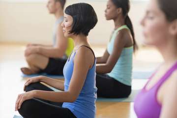 A group of people meditating in a yoga class.