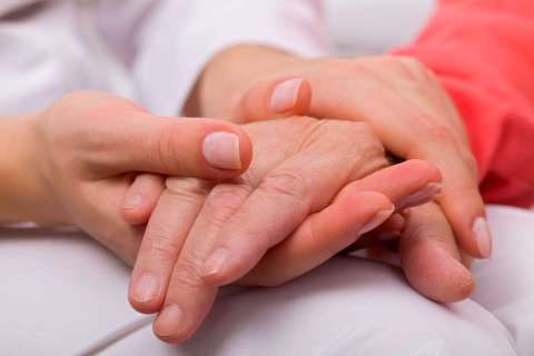 Holding elderly hand: young and elderly hands clasped in comfort