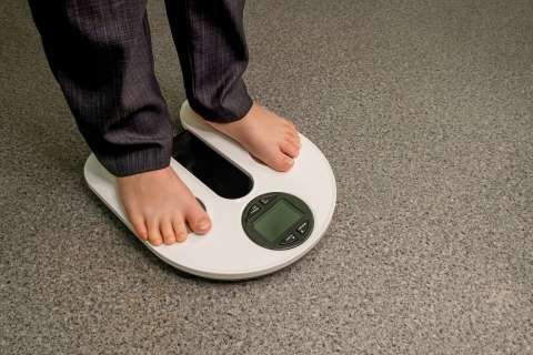 Health care, fitness and weight loss. Child on analytical balance.