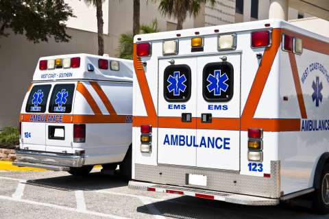 Two ambulances parked, showing rear doors with emergency medical symbols.