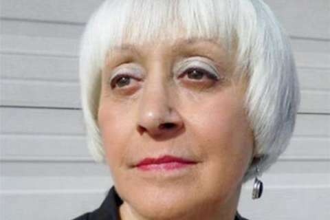 Headshot of Barbara Pytlewski with short silver hair and small hoop earring, neutral panel background