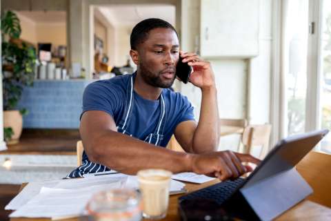 Gentleman on a phone call while using his laptop
