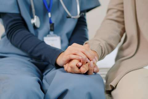 Nurse and patient family holding hands