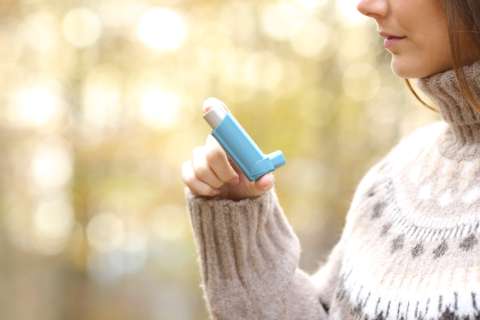 Woman using inhaler for respiratory disease