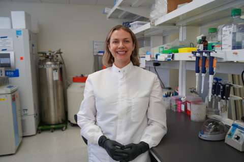 Dr. Amy Vandiver stands smiling in her UCLA lab.
