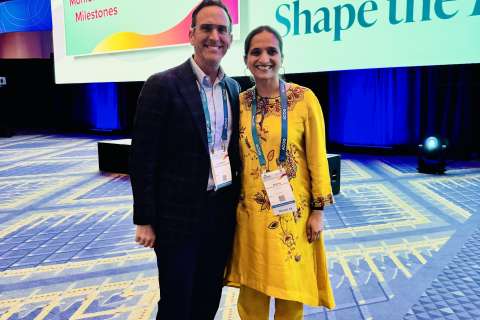 Christopher Tarnay, MD, MHA and Aparna Sridhar, MD, MPH at the ACOG District IX conference standing on stage.