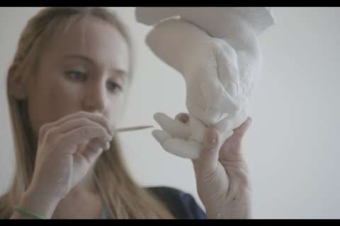 Carefully uncovering a hand casting