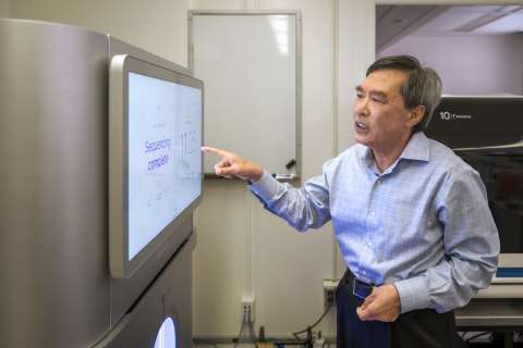 Man pointing at flat computer monitor screen