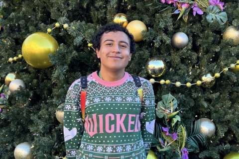 Brandon Chico in front of a Christmas tree.