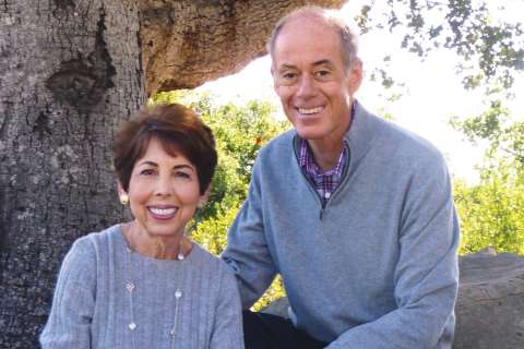 Connie Frank and Evan Thompson smiling outside.