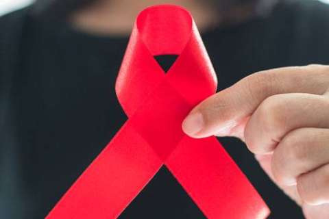 Woman holding a red AIDS awareness ribbon