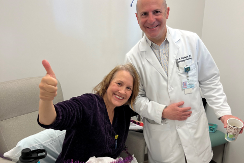 A happy patient with her doctor in a hospital room.