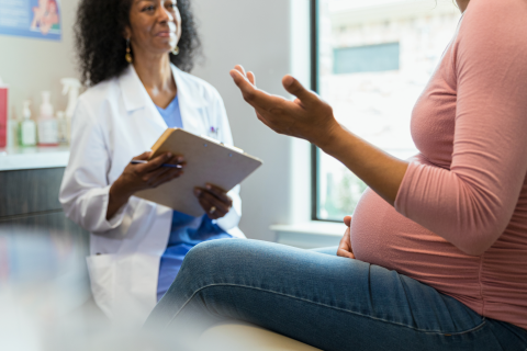 A pregnant woman speaks with her doctor.