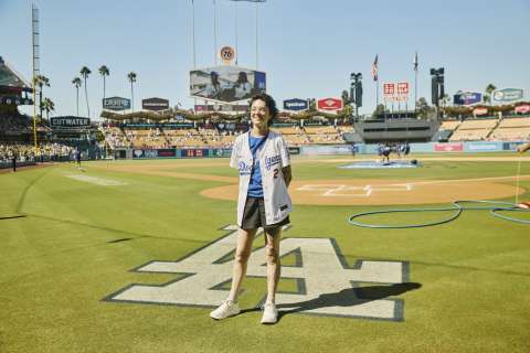 A woman stands near the LA logo on the field at Dodger Stadium.