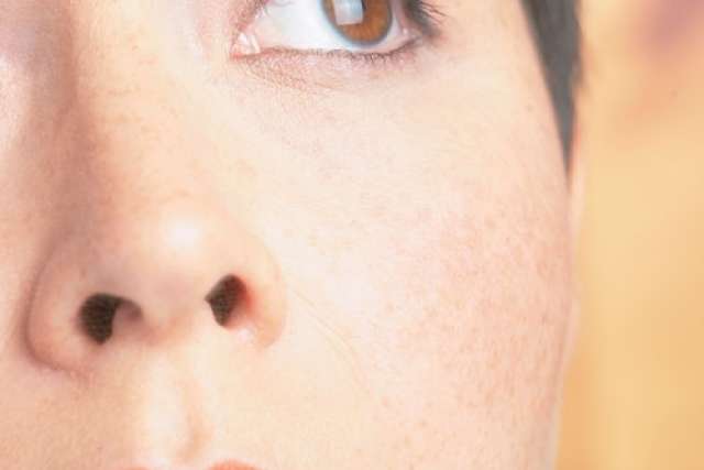 Close-up of a person’s face showing one eye, nose, and lips, looking slightly upward.