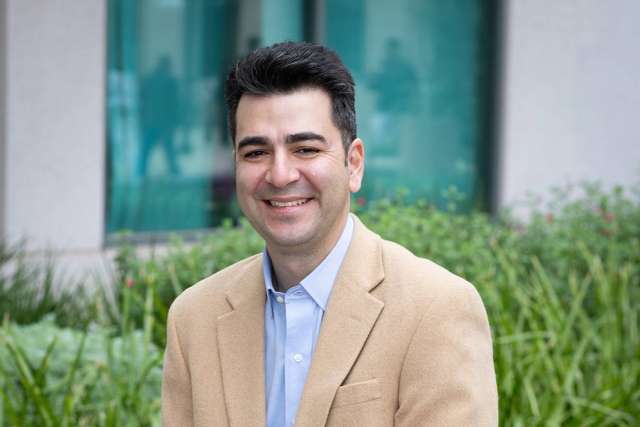 Cameron Kalunian smiling headshot in tan blazer outdoors