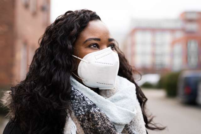 Woman in a covid mask, standing on a street