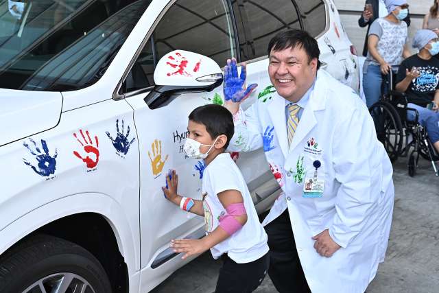 Dr. Steven Jonas and a patient at UCLA Mattel Children's Hospital put their handprints on a Hyundai during a celebration of Dr. Jonas receiving a $400,000 research grant.
