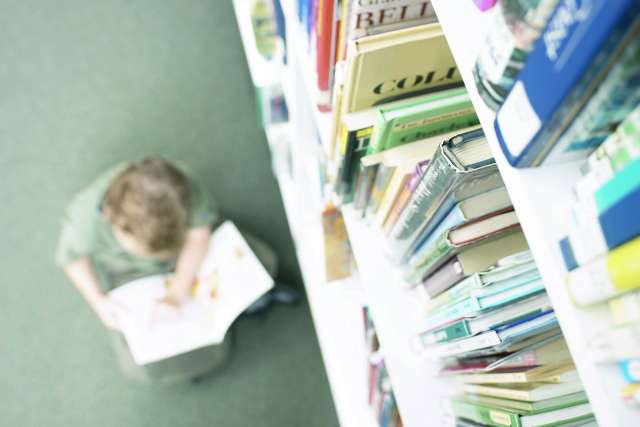A person reading a book in a library.