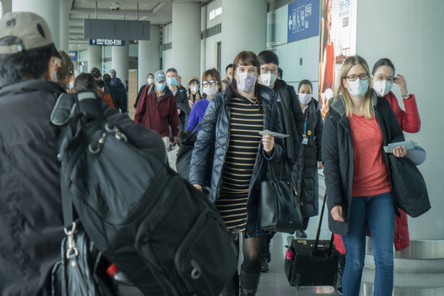 Travelers wearing face masks walk through Beijing Capital International Airport during the early COVID-19 outbreak in January 2020.