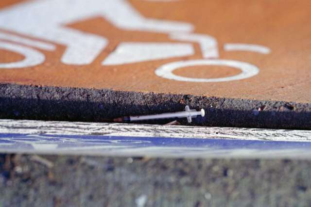 Used needle on street curb