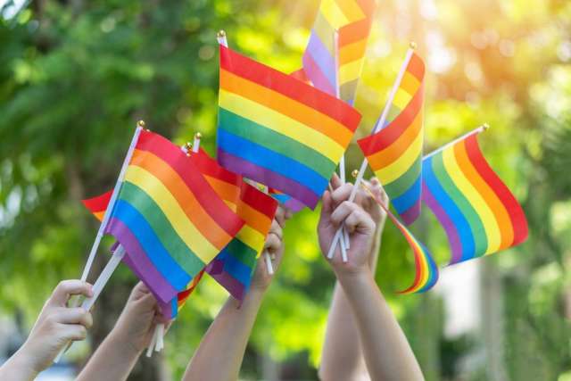 LGBTQ+ pride flags wave.