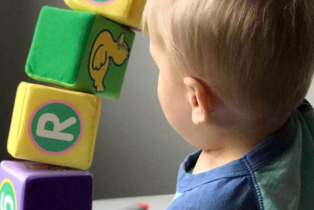 A child stacking blocks on top of each other