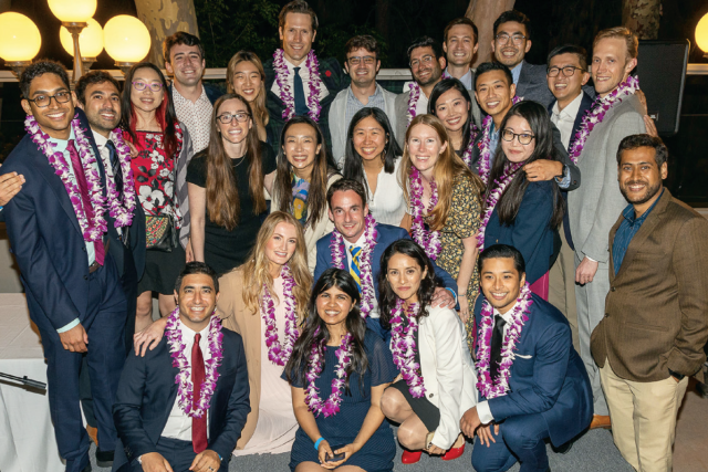 The 2022 Graduating Class of Residents & Fellows at the UCLA Department of Ophthalmology poses for a group photo, many wearing leis.