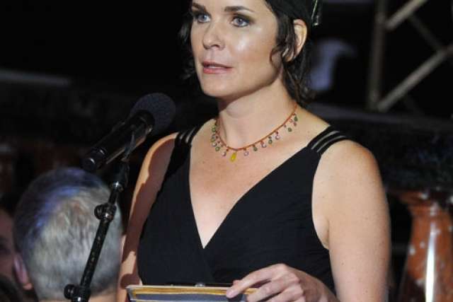 Jeannine Walston speaking at Visionary Ball, holding notes at a microphone