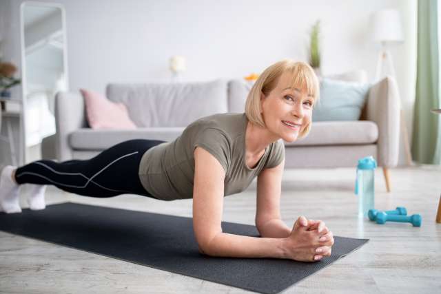 Positive mature lady exercising indoors