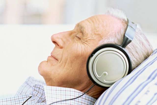 Person lying down wearing large over-ear headphones.