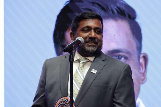 Dr. Raj Rajaraman speaks at a microphone after receiving the TSC Alliance's Champion Award in recognition of his care for Tuberous Sclerosis Complex patients.