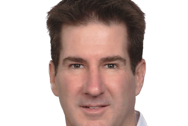 Portrait of person in navy sweater and white collared shirt